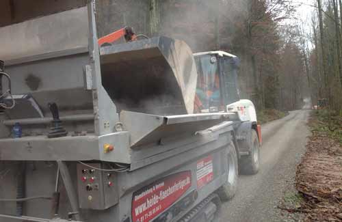 Der Fertiger beim Wegebau in Nürnberg. Maschinelle Herstellung einer Wegedecke für einen Wanderweg.